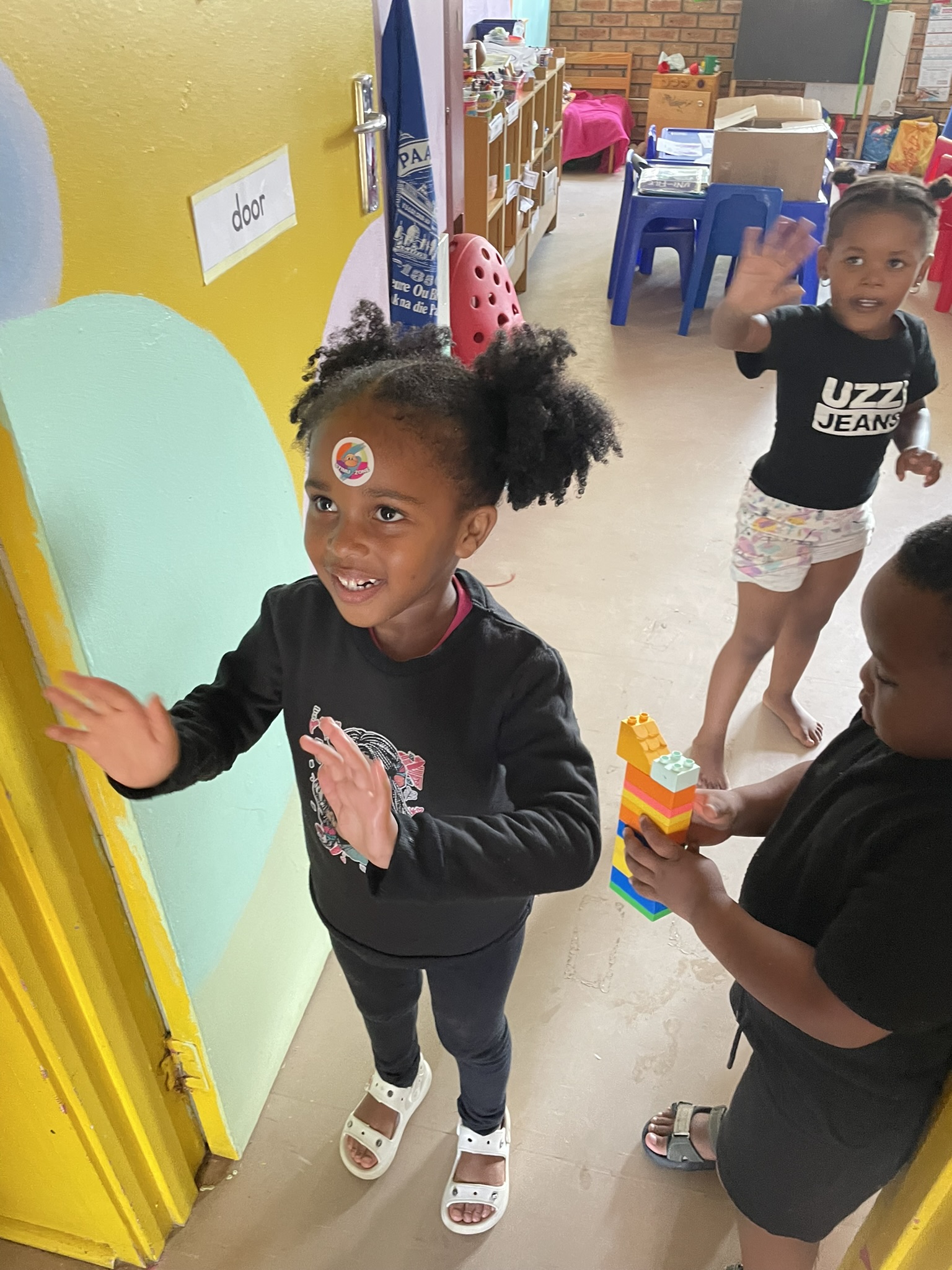 Kindergarten Kind mit macht quatsch mit Sticker auf der Stirn.